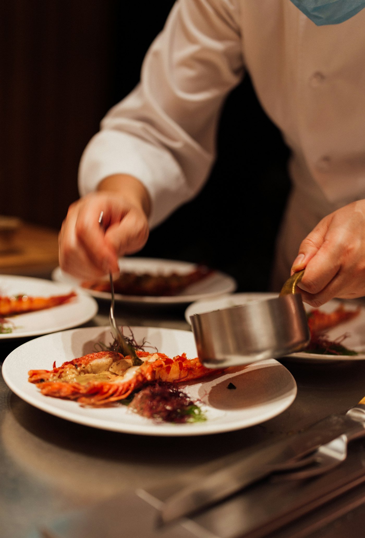 Mains de cuisinier dressant une assiette